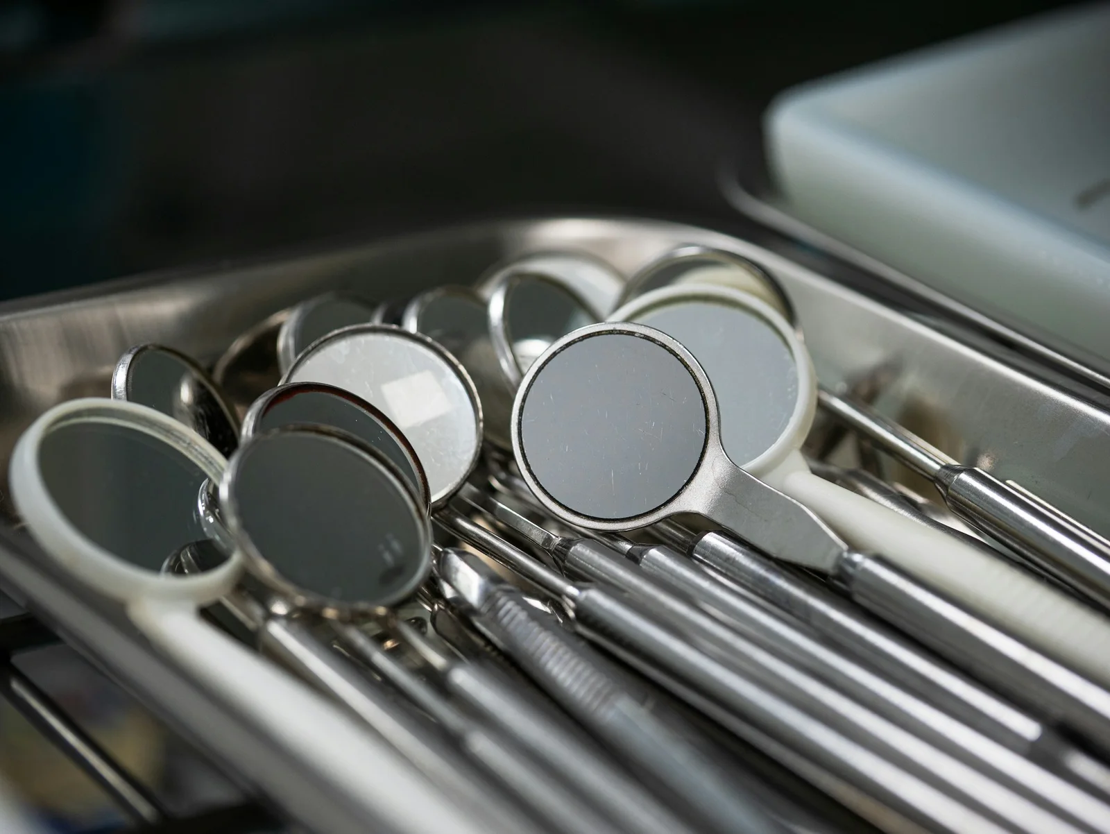 Miroirs et instruments de dentiste en acier alignés sur un plateau métallique, en gros plan